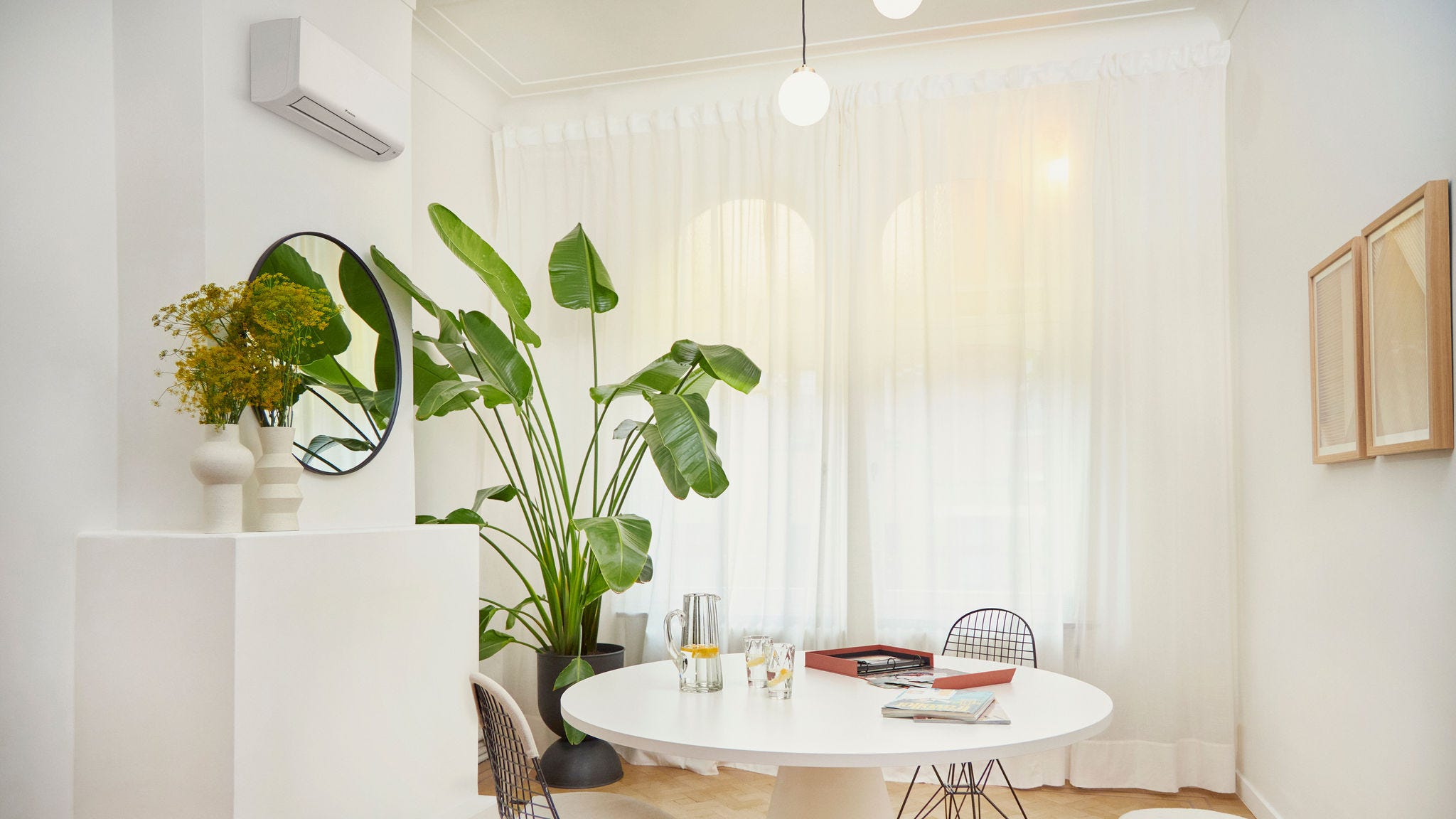White living room with photo album on round table and plants in the room