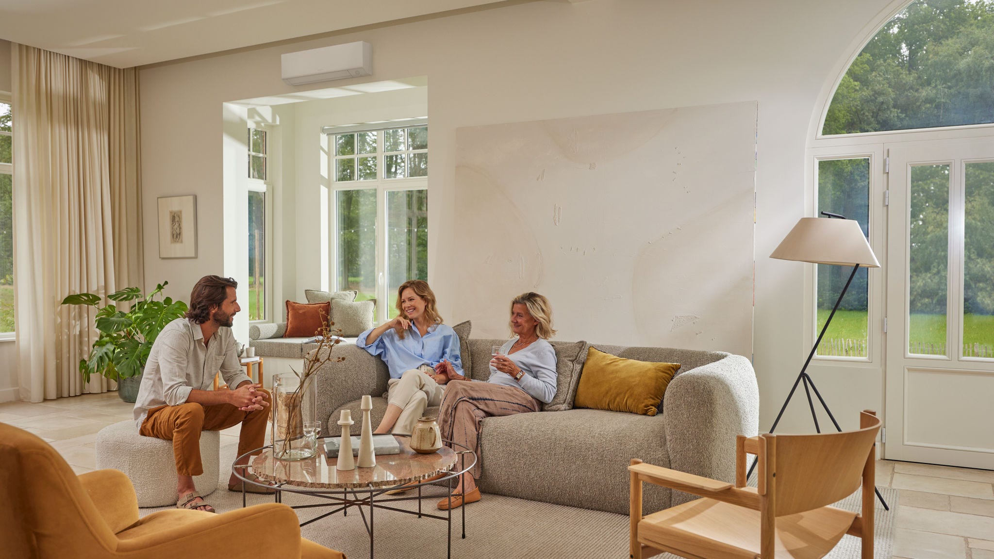 Family relaxing in living room with wall mounted air conditioner