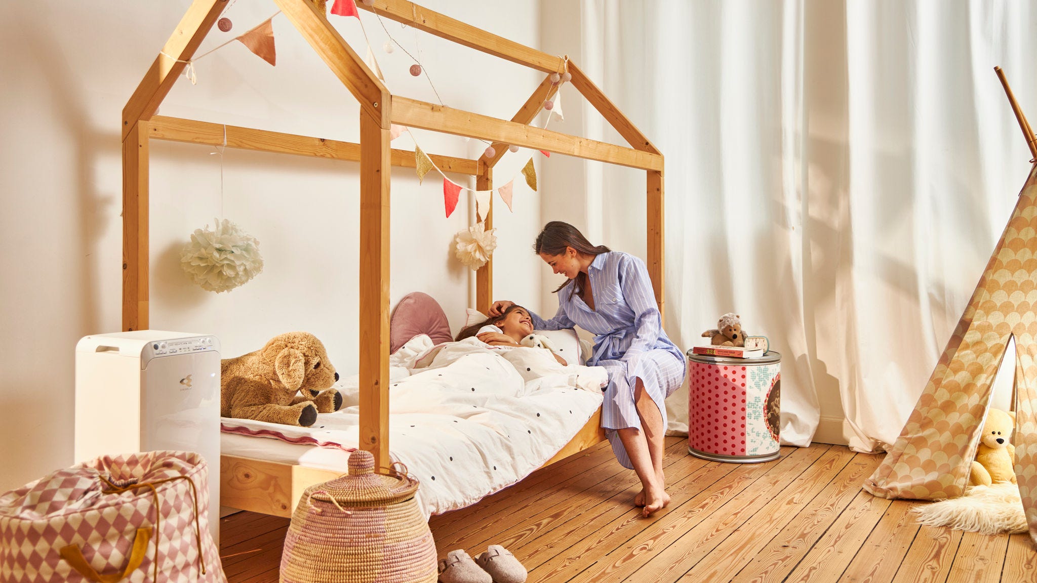 Mother putting child to bed in their healthy home thanks to the Daikin air purifier in the children's room