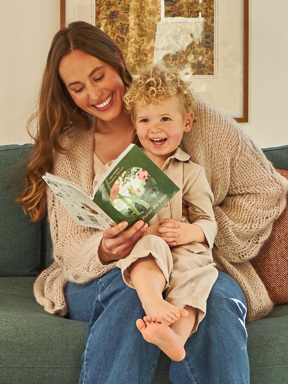 Mother and toddler on her lap looking in a little book