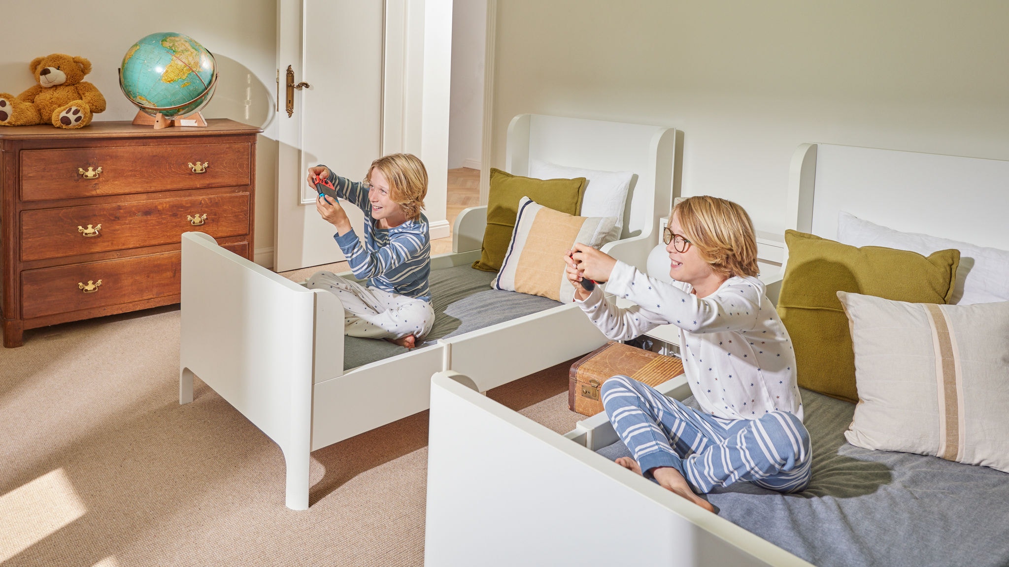 Two children play happily together in their bedroom