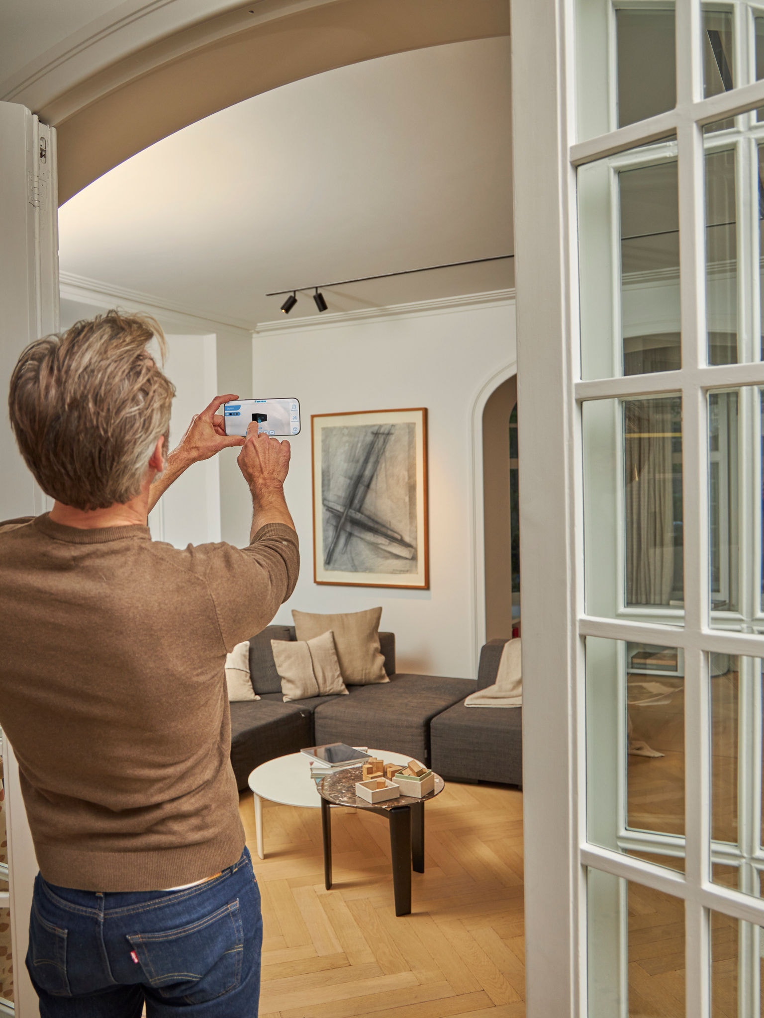Man using the 3D app with augmented reality air-to-air heat pumps to visualize the units with the interior and exterior design