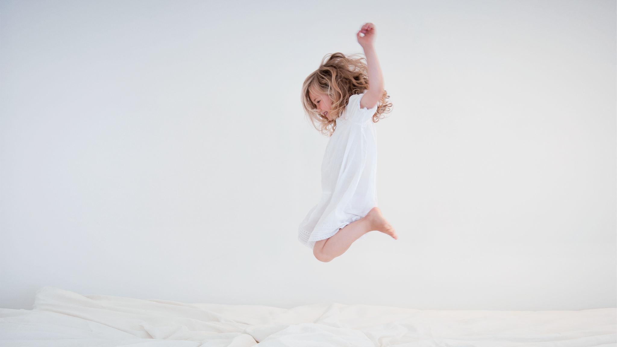 Child jumping on the bed in her bedroom with purified air thanks for the air purifier