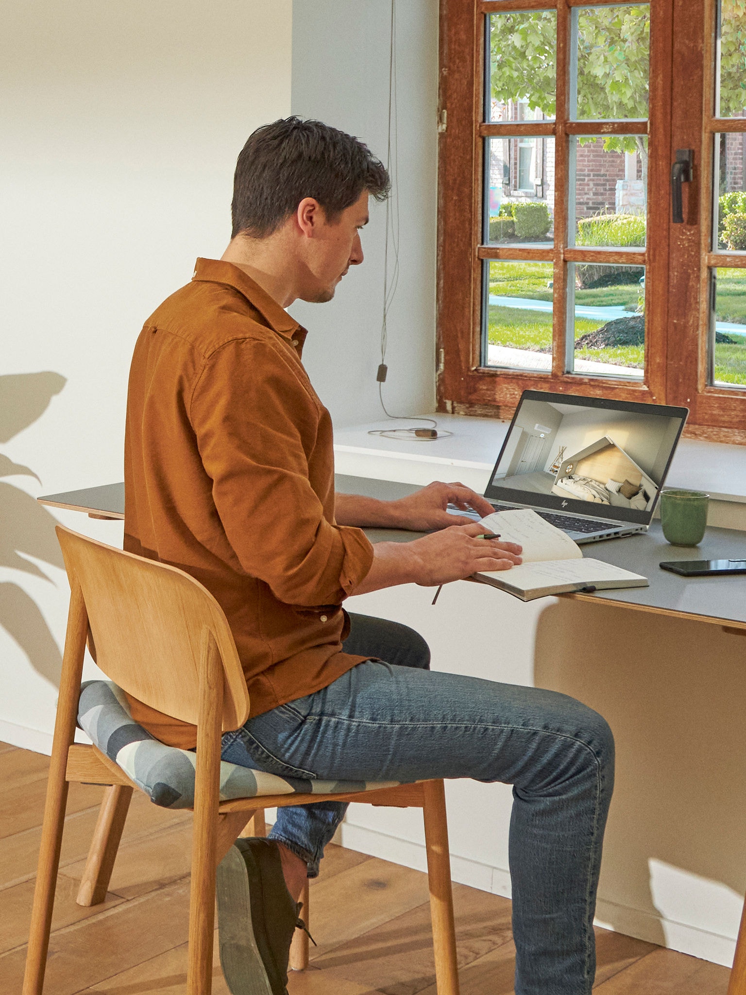 Man sitting at his desk viewing air conditioners on the virtual experience centre on his laptop