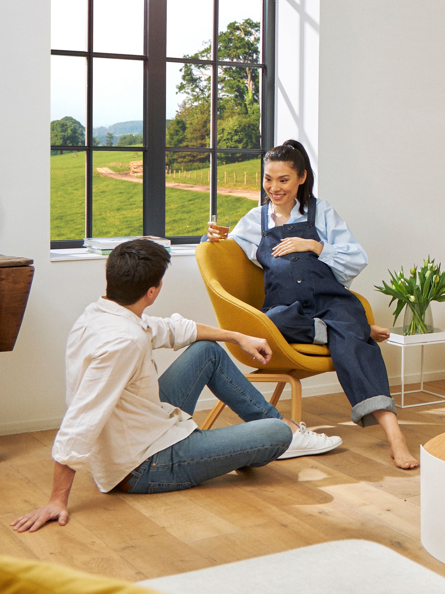 Pregnant couple lounging in their living room in a comfortable temperature provided by a Daikin heat pump