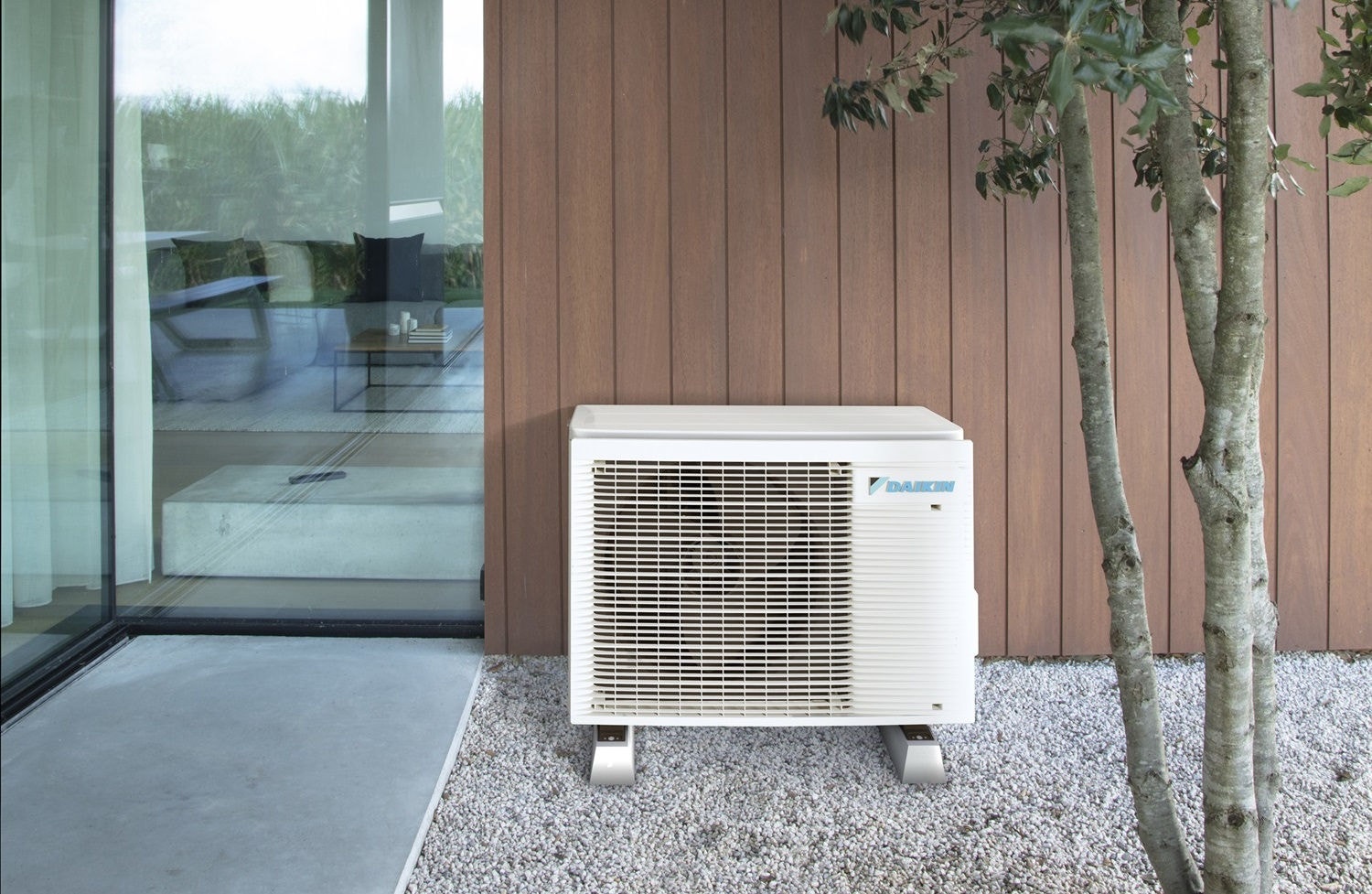 Daikin outdoor unit on gravel outside modern home