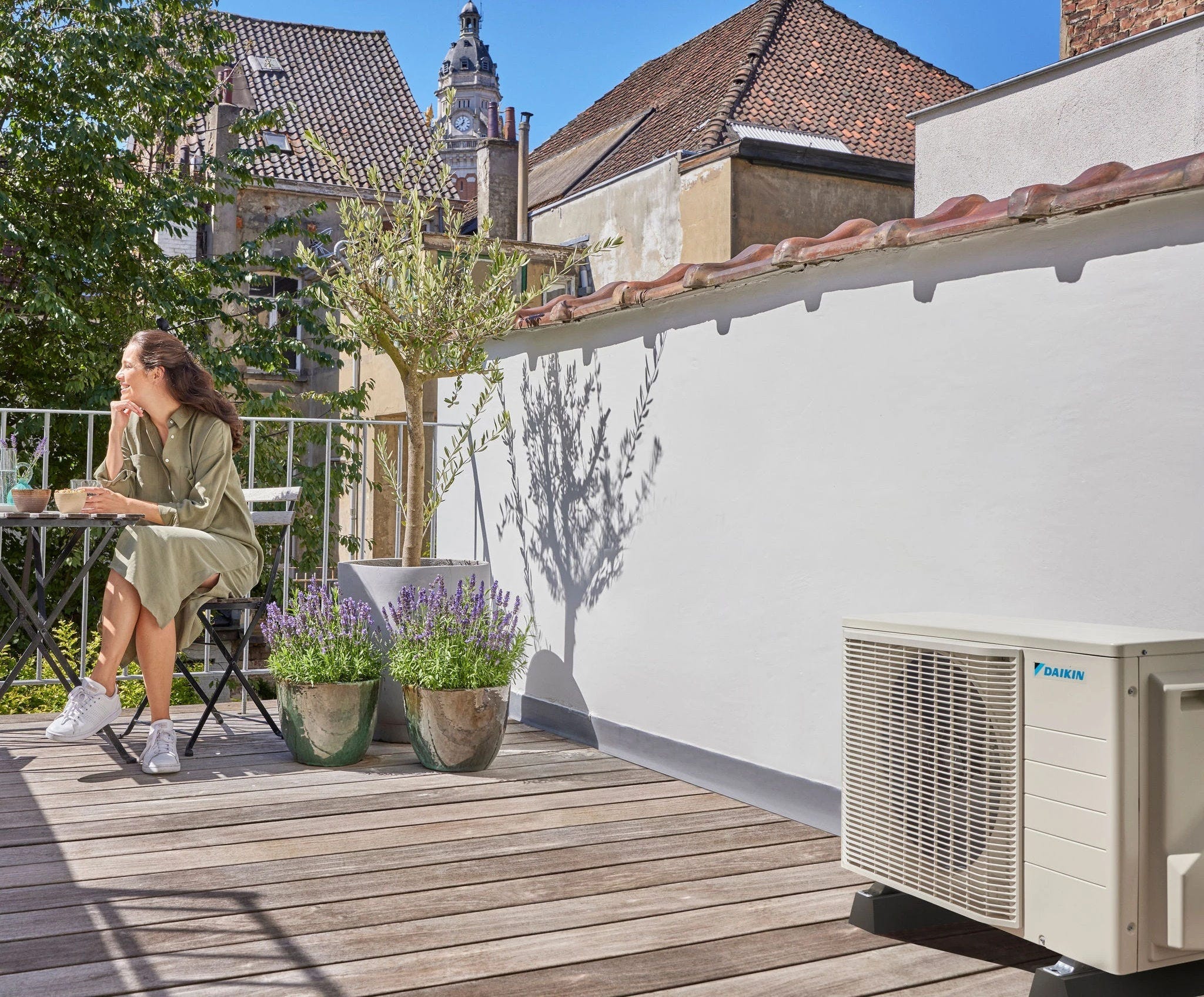 Man reading on a bench outside his house beneath a Daikin air source heat pump.
